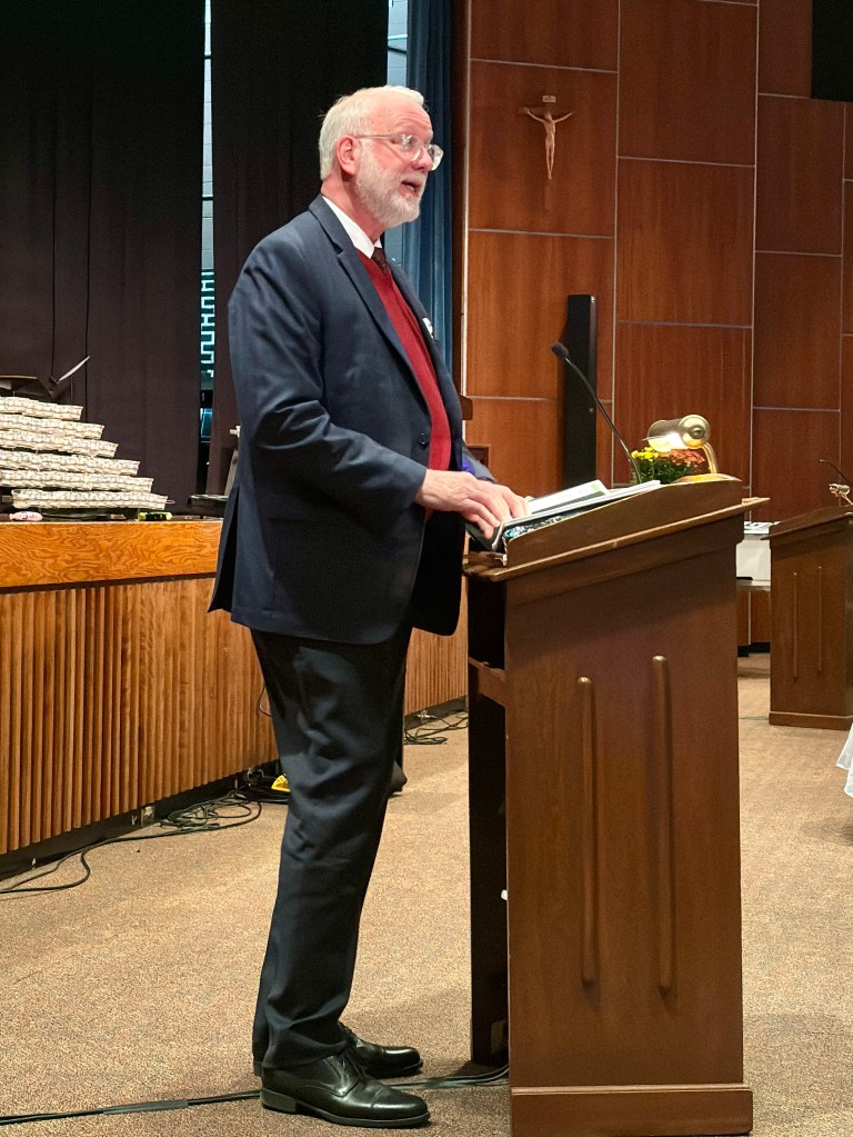 a man in a business suit speaking at a podium