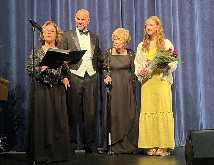 photo of an award recipient on stage along with presenters